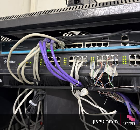 ציוד מרכזיית IP ומתג רשת מותקנים בתוך ארון תקשורת